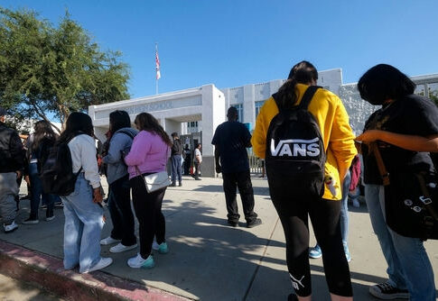 Students standing outside a high school entrance