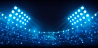 Football stadium under bright lights at night.