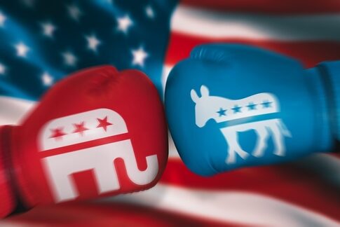 Red and blue boxing gloves representing Republican and Democratic parties against an American flag background