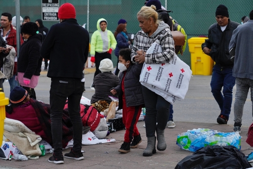 shutterstock_2238811869.jpg featured image People at an outdoor relief station with Red Cross supplies.