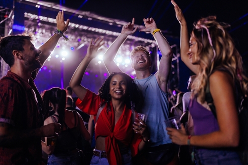 shutterstock_2272515487.jpg featured image Group of people dancing and smiling at a concert.