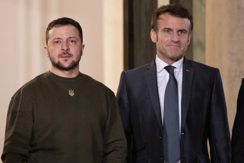 Two men standing side by side, dressed formally.