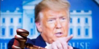 Gavel in front of a blurred person pointing