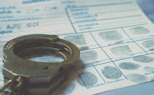 Handcuffs on a fingerprint form document.