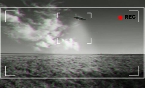 Black and white footage of UFO over a field.
