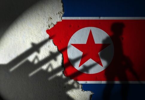Silhouette of a soldier against a North Korean flag background