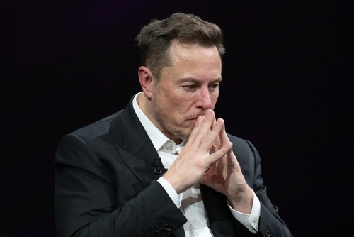 shutterstock_2318800313 (1).jpg featured image Elon Musk deep in thought, hands clasped near face.