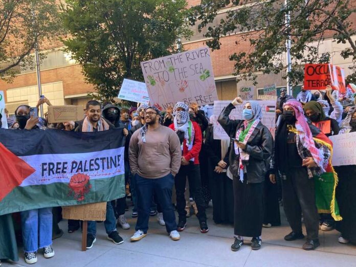 shutterstock_2374681249.jpg featured image Protesters gather holding Free Palestine signs and banners.
