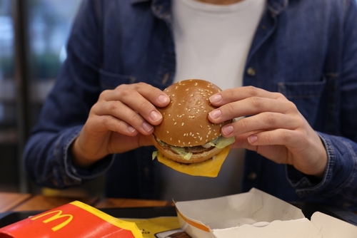 shutterstock_2384976221.jpg featured image Person holding a McDonald's burger in their hands.