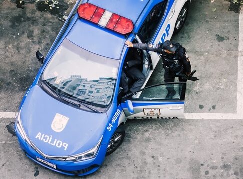 Police officer interacting with a police car in an urban environment