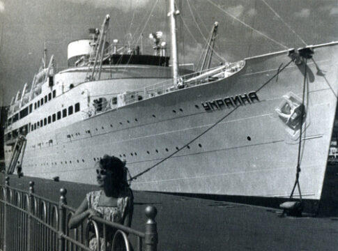 A large ship named docked at a pier.