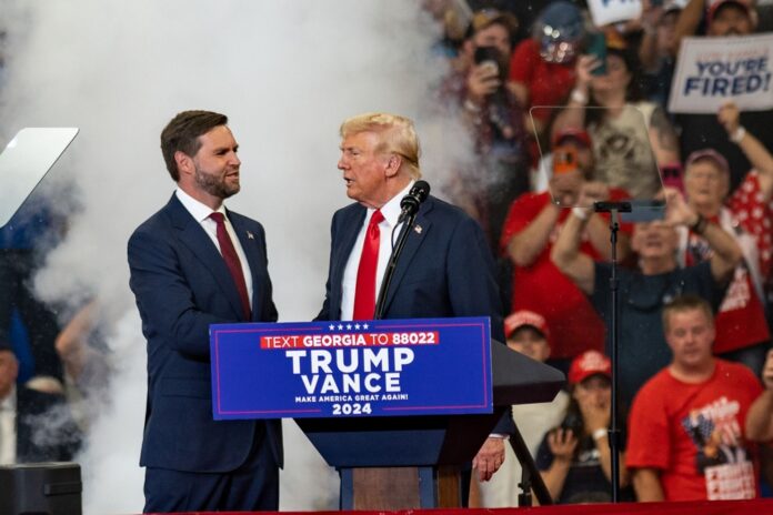 shutterstock_2499200129 featured image Two men at a political rally stage event