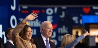 People waving at an event indoors smiling joyfully