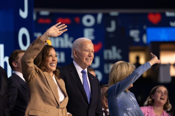 People waving at an event indoors smiling joyfully