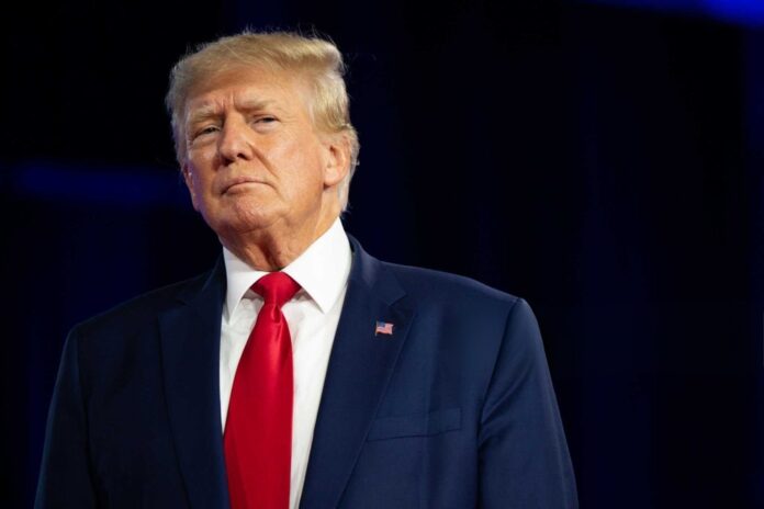 donald trump in suit with red tie standing