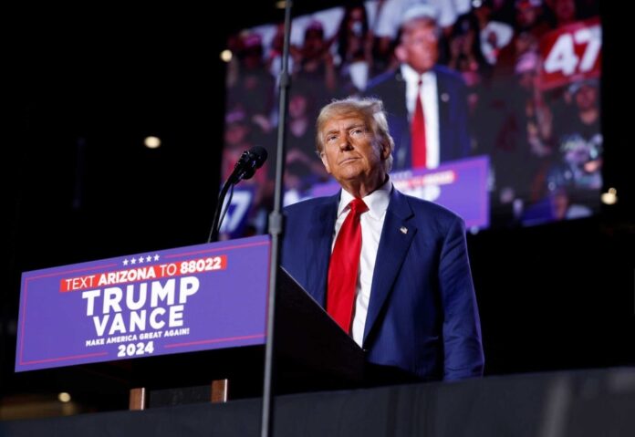Person standing at podium with audience in background