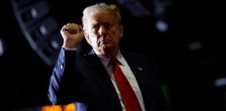 Man in suit raises fist during event