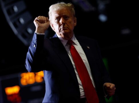 Man in suit raises fist during event