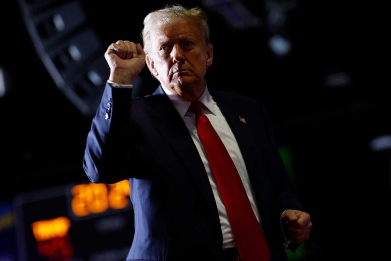 Man in suit raises fist during event