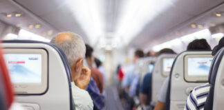 People seated inside an airplane cabin.