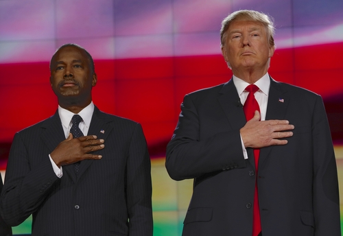 Two men with hands over hearts during anthem.