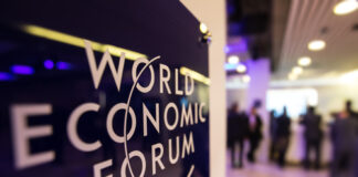 World Economic Forum sign with blurred people in background.