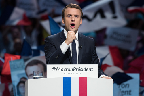shutterstock_623078429.jpg featured image Emmanuel Macron at a campaign rally podium.