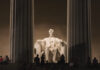 Night view of the Lincoln Memorial with a statue of Abraham Lincoln seated