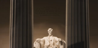 Night view of the Lincoln Memorial with a statue of Abraham Lincoln seated